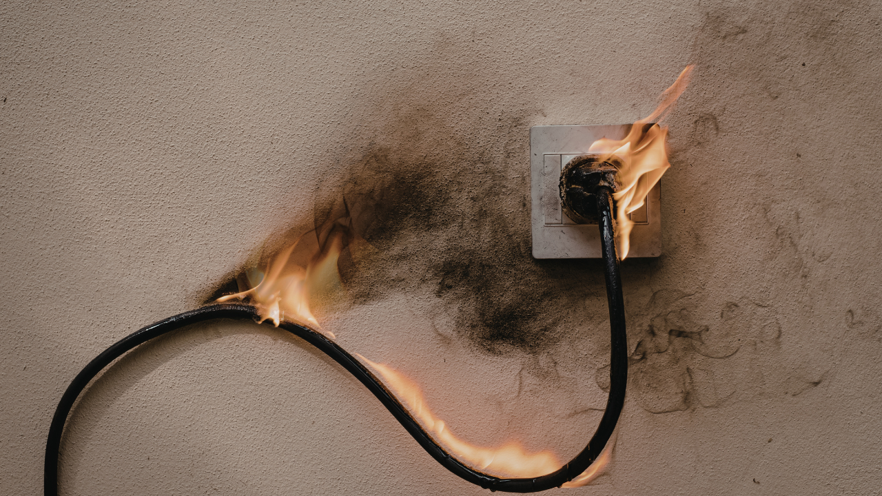Burn marks and sparks near a residential wall outlet indicating electrical hazard